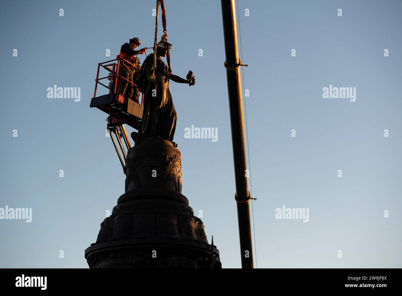 Arlington, Stati Uniti d'America. 20 dicembre 2023. I lavoratori attaccano la tessitura alla statua di bronzo del Confederate Memorial nella sezione 16 del Cimitero Nazionale di Arlington prima della rimozione con gru, il 20 dicembre 2023 ad Arlington, Virginia. Il memoriale in onore dei membri degli Stati Confederati d'America viene trasferito al New Market Battlefield State Historic Park. Credito: Elizabeth Fraser/U.S. Army/Alamy Live News Foto Stock