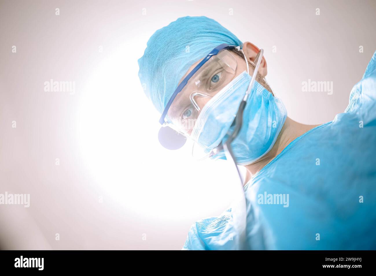 Medico chirurgo maschio in sala operatoria che guarda il paziente alla telecamera Foto Stock
