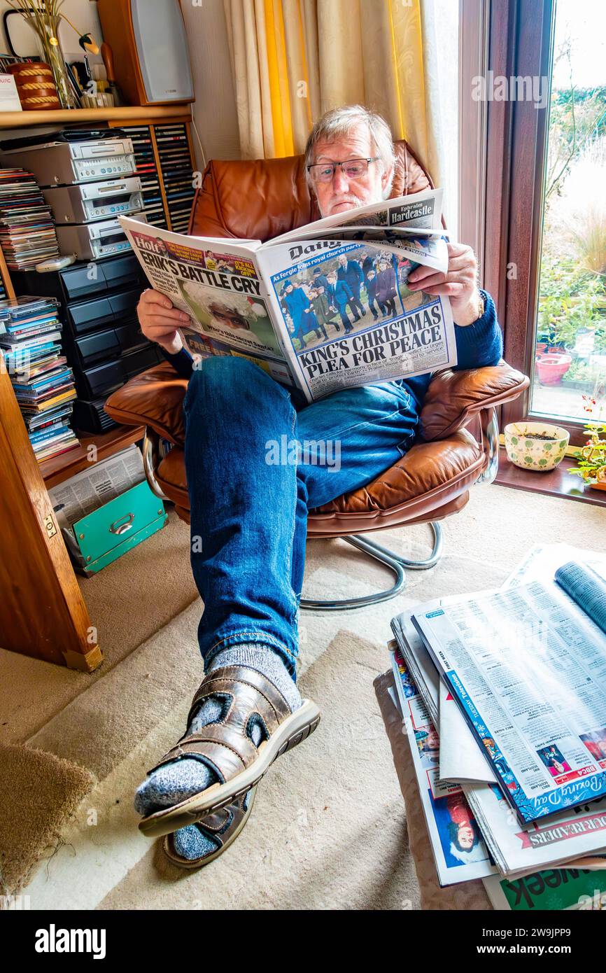 Un uomo si rilassa su una poltrona e legge il quotidiano Daily mail il giorno di Santo Stefano 2023 Foto Stock