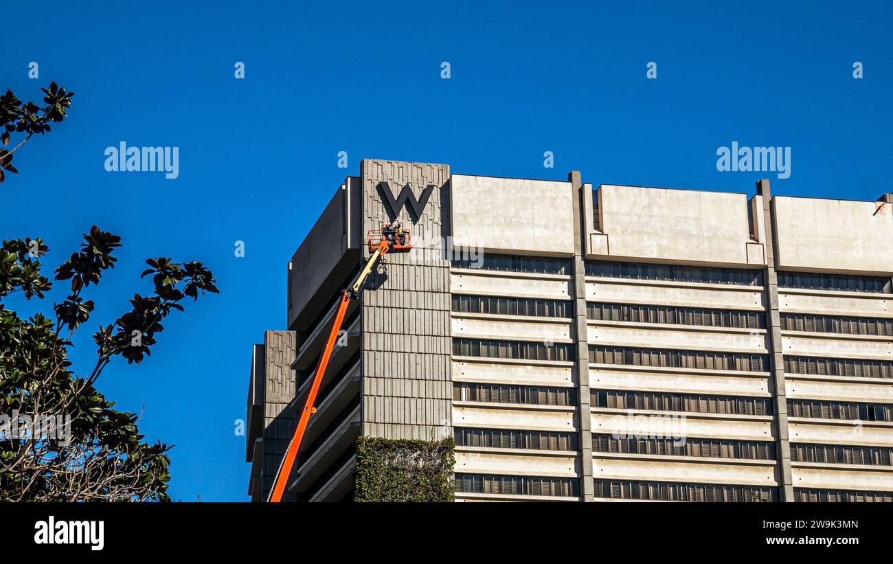 Un lavoratore su un pick-up di ciliegie che pulisce il cartello dell'hotel W a Westwood, Los Angeles, California Foto Stock