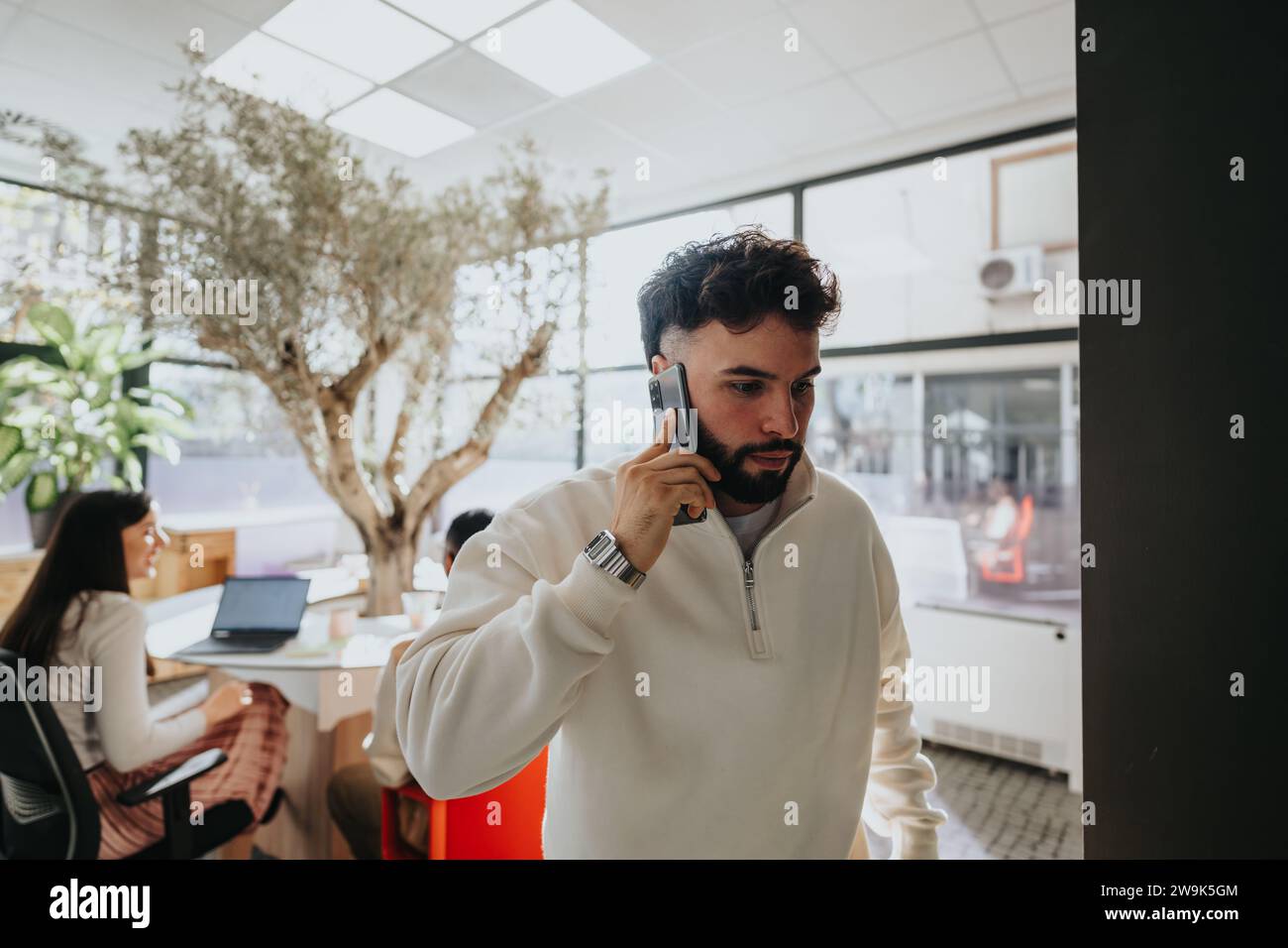 Un impiegato che lascia l'ufficio, sta facendo una telefonata. Foto Stock