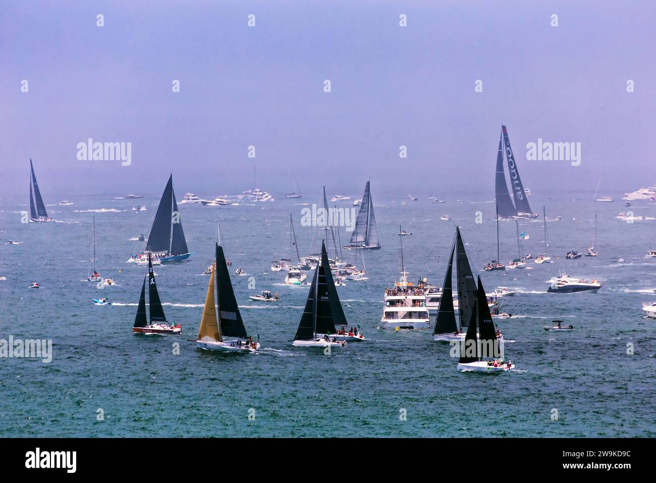 Sydney, Australia - 26 dicembre 2023: Sydney Hobart Yacht Race fuori dalla linea di partenza fuori dal porto di Sydney con Andoo in testa. Foto Stock