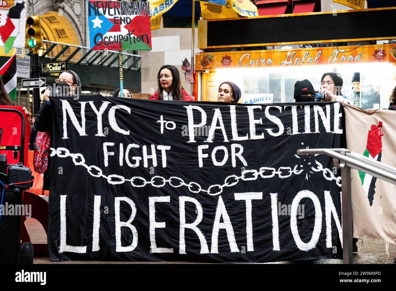 New York, Stati Uniti. 28 dicembre 2023. I manifestanti tengono uno striscione che dice "New York in Palestina, lotta per la liberazione" durante una manifestazione a sostegno della Palestina/Gaza nel Parco Zuccotti a New York. Credito: SOPA Images Limited/Alamy Live News Foto Stock