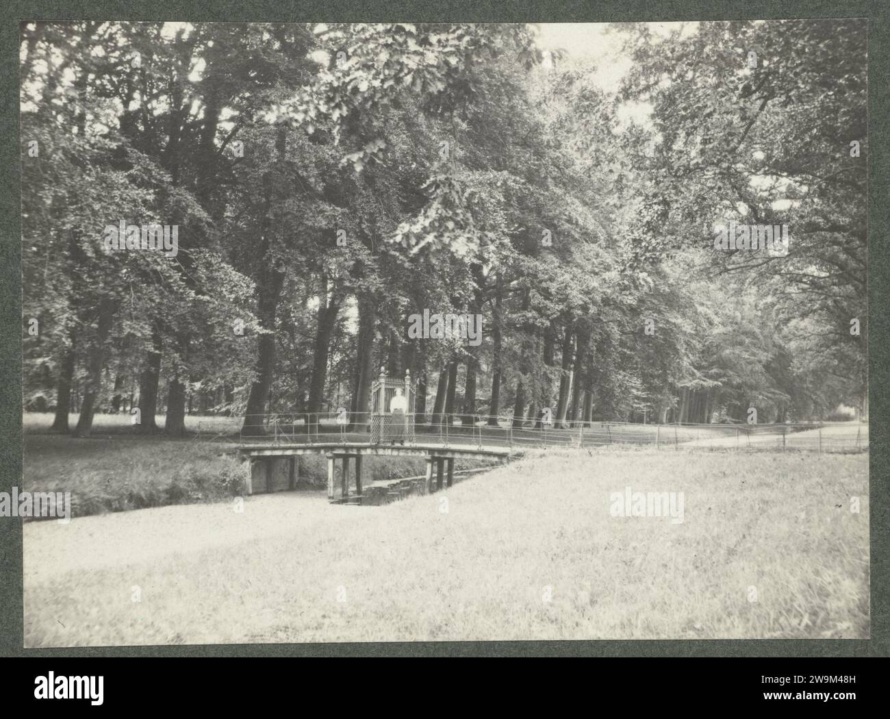 Donna su un ponte nel giardino della tenuta De Paauw, c. 1913 Fotografia carta olandese. Supporto fotografico Huize De Paauw Foto Stock