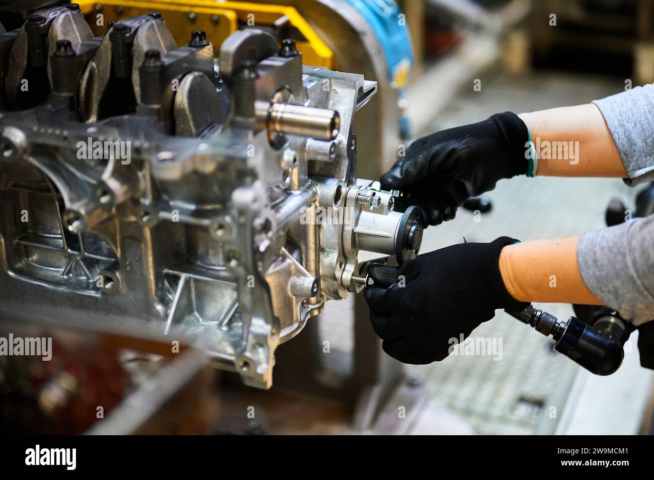 Assemblaggio del motore dell'auto a mano dell'operatore nel primo piano dell'officina Foto Stock