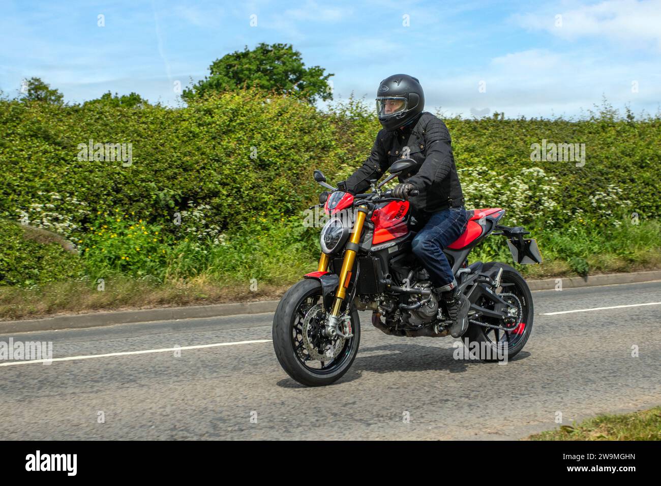 Motociclisti sportivi in stile retrò Ducati sull'autostrada M61 nel Regno Unito; viaggiando sull'autostrada M6 a Greater Manchester, nel Regno Unito Foto Stock