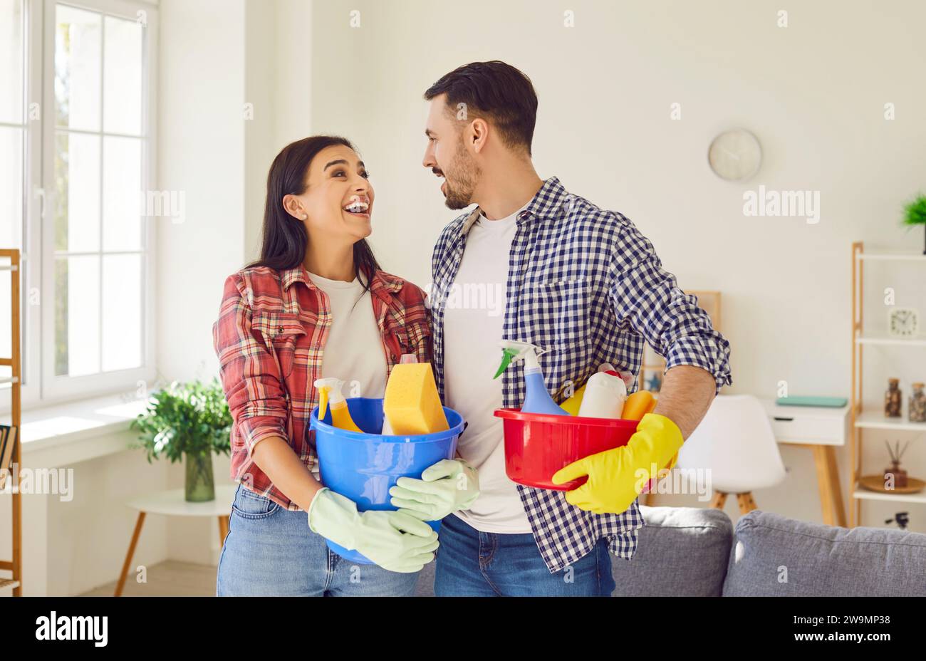 Ritratto di una coppia sorridente che pulisce il soggiorno Foto Stock