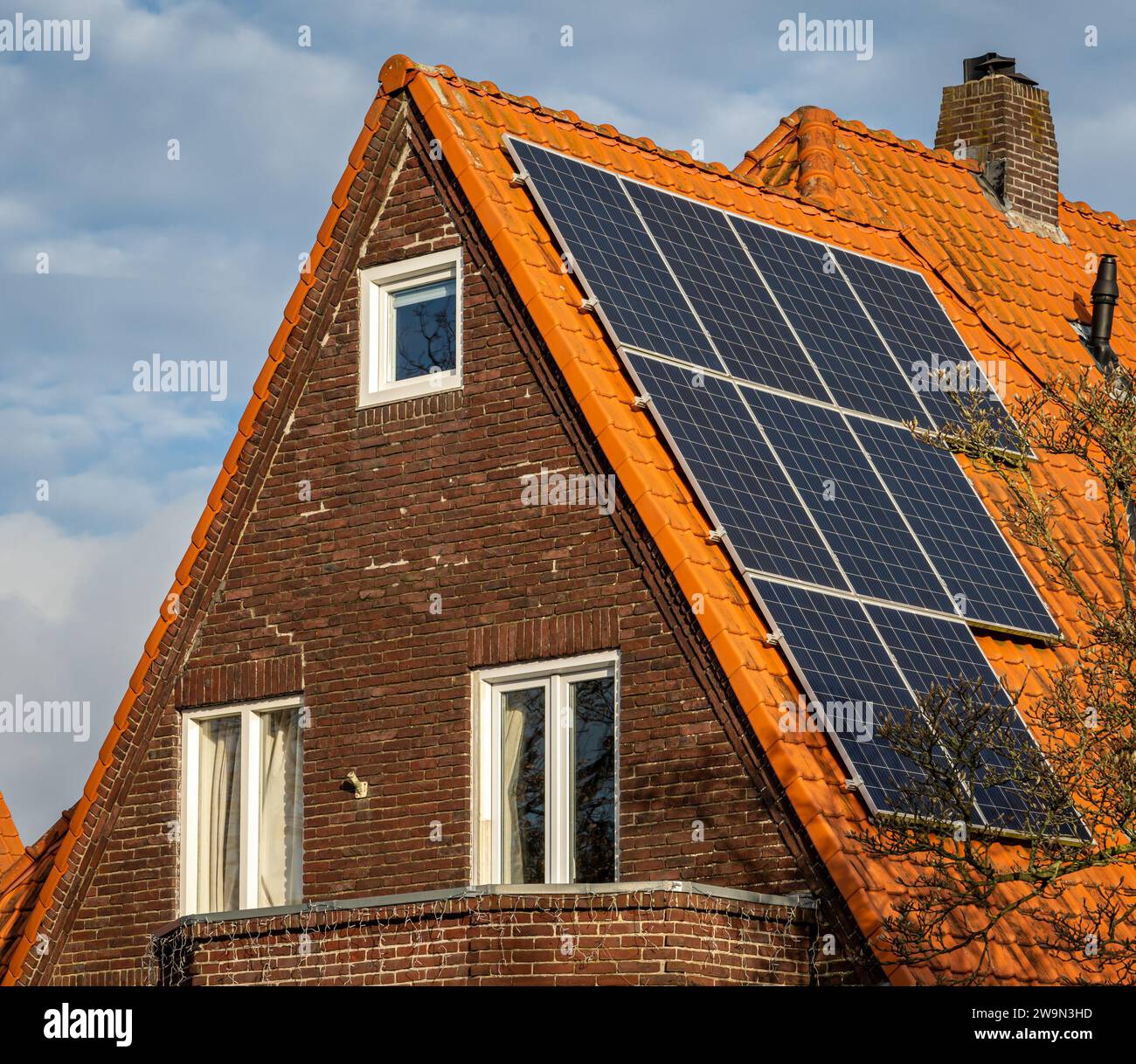 Pannelli solari sul tetto, casa olandese con piastrelle arancioni e pannelli fotovoltaici Foto Stock