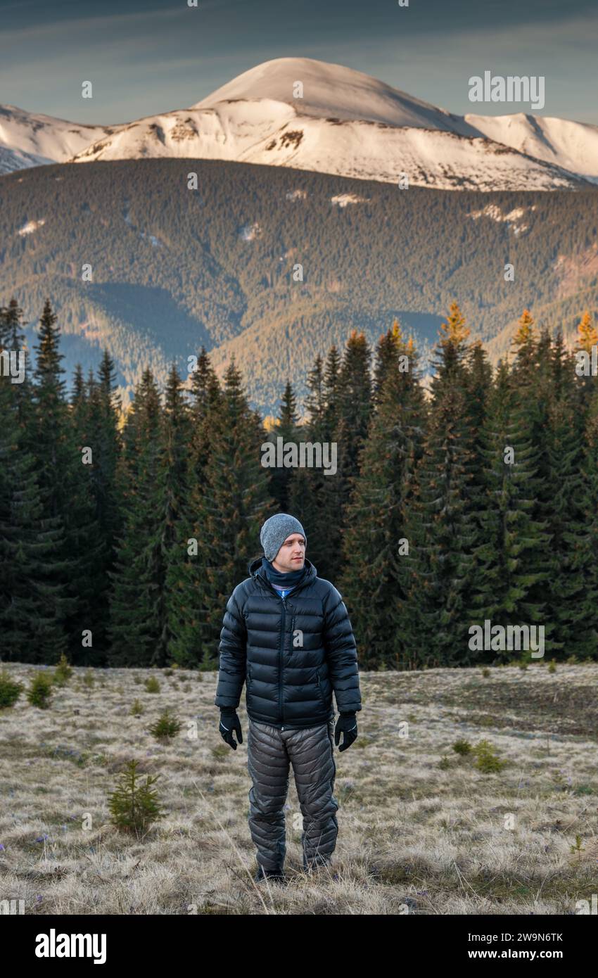 Giovane uomo in abiti caldi, escursione all'alba Foto Stock