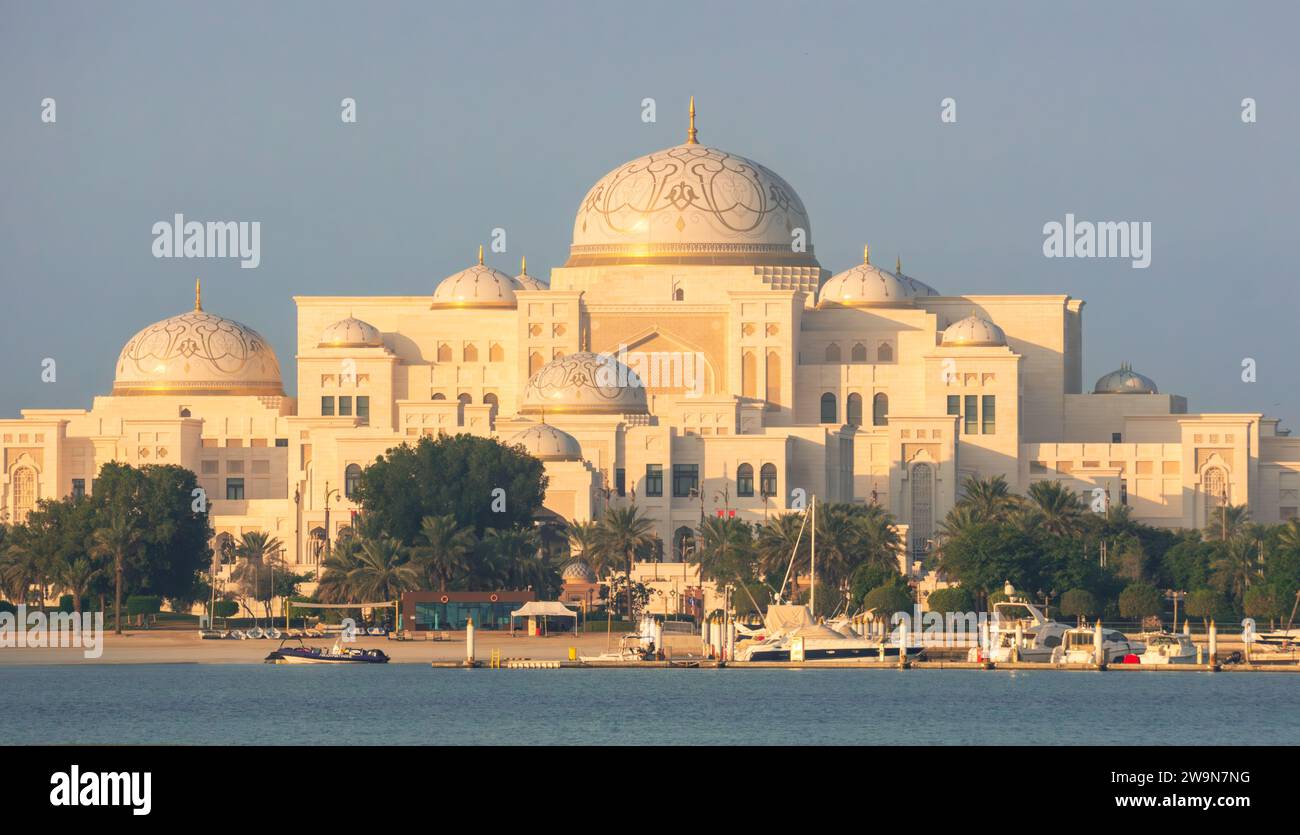 Il palazzo di Qasr al Watan ad Abu Dhabi all'alba, Emirati Arabi Uniti. Cielo azzurro, sole basso e ombre lunghe. Marmo bianco, architettura araba. Foto Stock