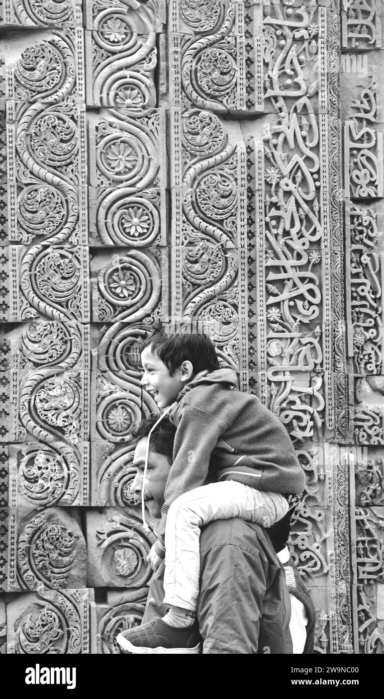 il bambino siede sulla spalla del padre, complesso qutub minar Foto Stock