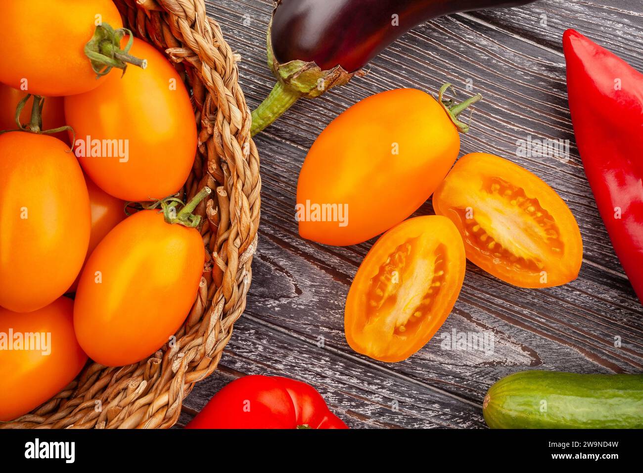 pomodoro all'arancia e prugna a fette su fondo di legno Foto Stock