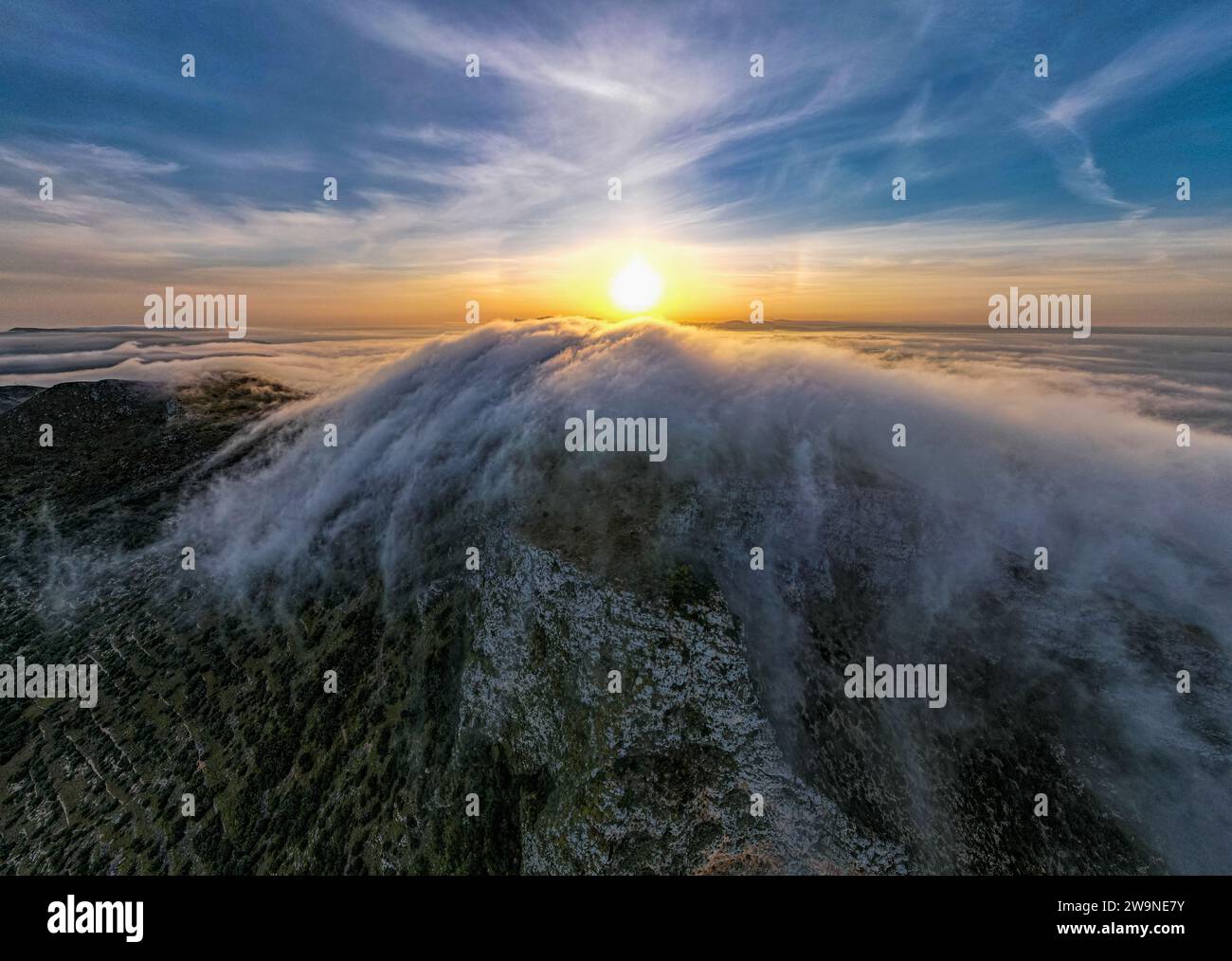 Sicilia 2023. Nuvole che si arrampicano sul Monte Santa Caterina sull'isola di Favignana. Dietro vediamo il sole all'alba. Luglio 2023 Trapani, Italia Foto Stock