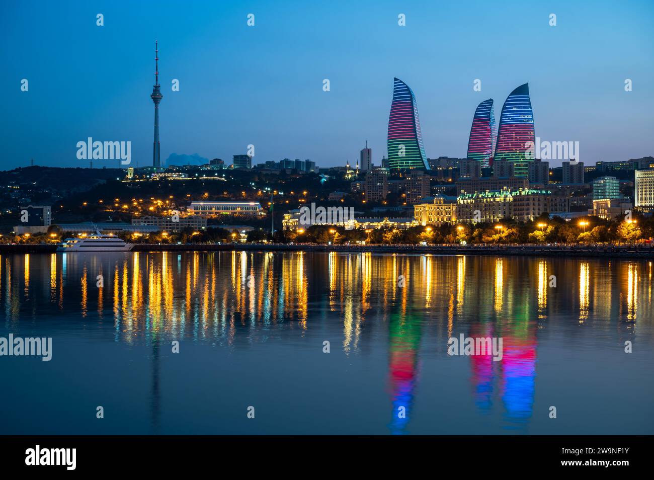 Vista notturna dello skyline di Baku, capitale dell'Azerbaigian, con riflesso delle Torri delle fiamme nelle acque del Mar Caspio. Foto Stock