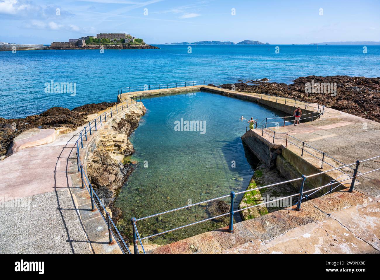 La Vallette Gent's piscina all'aperto, con Castle Cornet in distanza, a St Peter Port, Guernsey, Isole del Canale Foto Stock
