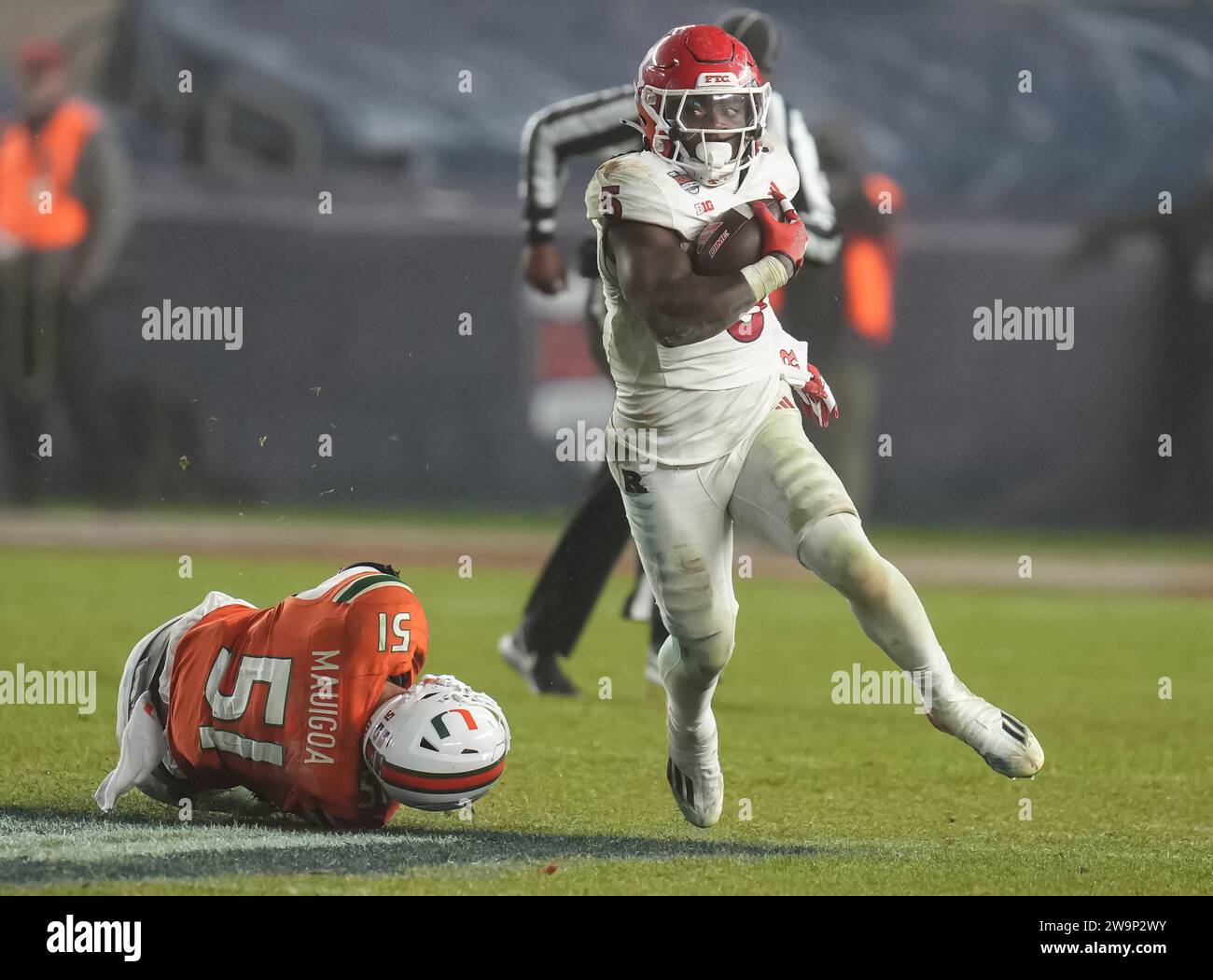 Il running back dei Rutgers Scarlet Knights Kyle Monangai (5) corre sul campo mentre il linebacker dei Miami Hurricanes Francisco Mauigoa (51) si tuffa per cercare di afferrarlo durante la partita di football universitario dei Boy Mowers Pinstripe Bowl del terzo periodo tra i Rutgers Scarlet Knights e i Miami Hurricanes il 28 dicembre 2023 allo Yankee Stadium nel Bronx, New York. Rutgers batte Miami 31-21 (David Venezia / immagine dello sport) Foto Stock