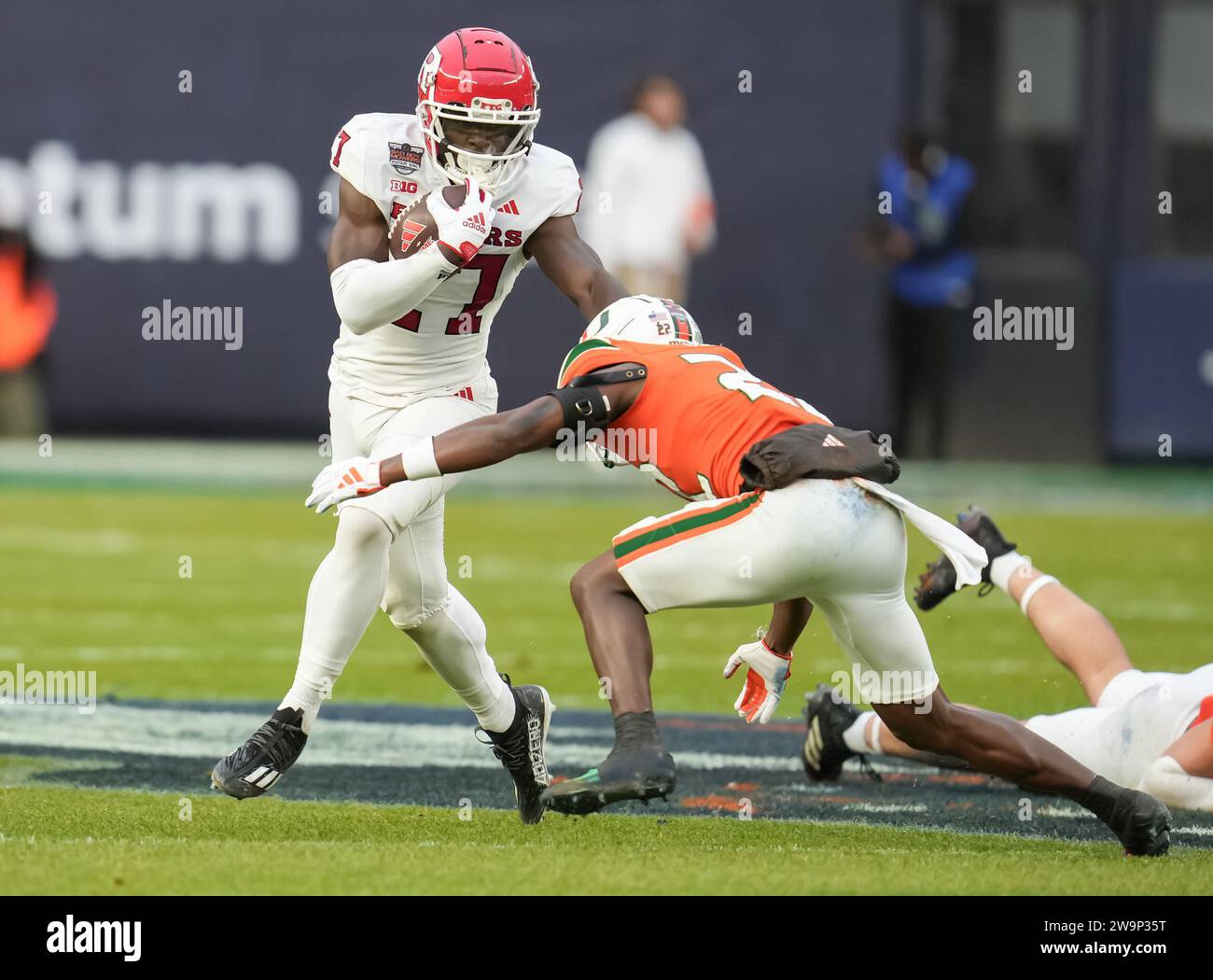 Rutgers Scarlet Knights running back Samuel Brown V (27) stiff Arms linebacker dei Miami Hurricanes K.J. Cloyd (23) durante la partita di football universitario dei Boy Mowers Pinstripe Bowl del secondo quarto tra Rutgers Scarlet Knights e Miami Hurricanes il 28 dicembre 2023 allo Yankee Stadium nel Bronx, New York. Rutgers batte Miami 31-21 (David Venezia / immagine dello sport) Foto Stock