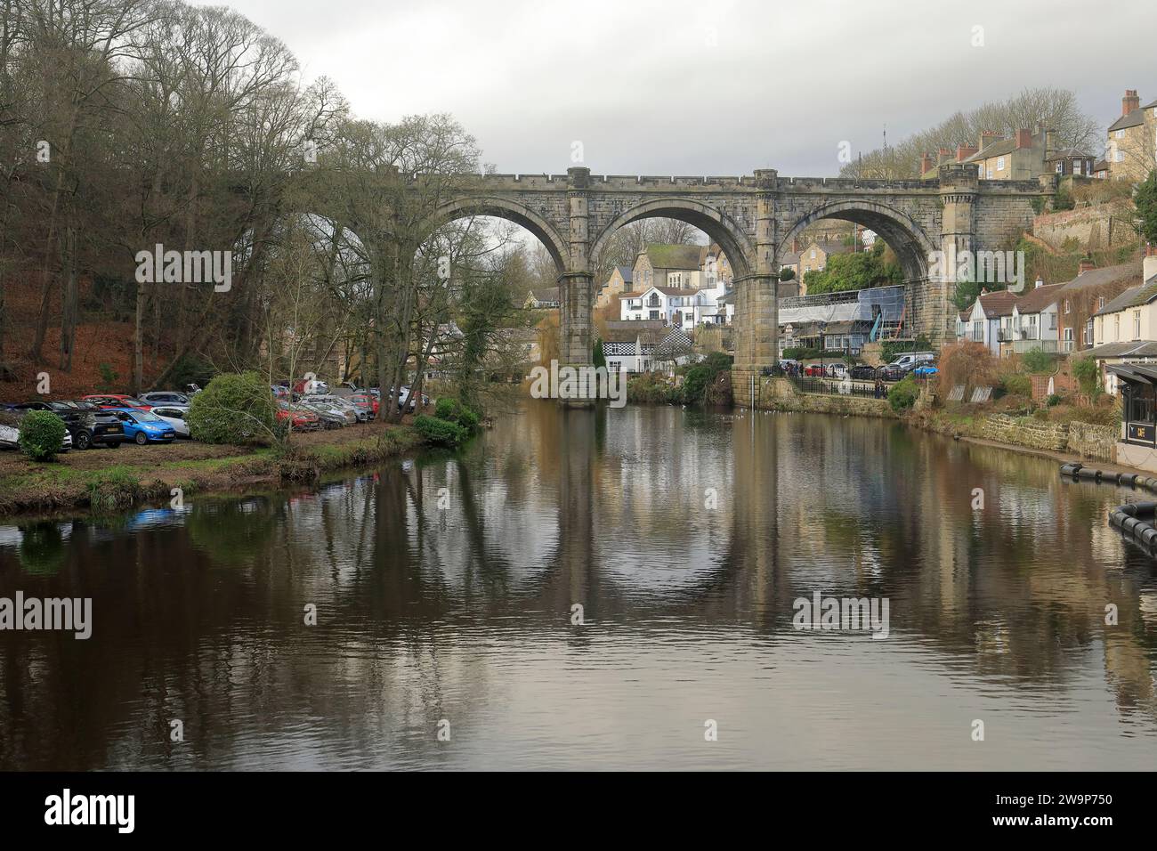 Vista del viadotto di Knaresborough riflessa nell'acqua in una giornata nuvolosa con la passeggiata lungo il fiume e la città alle spalle. Foto Stock