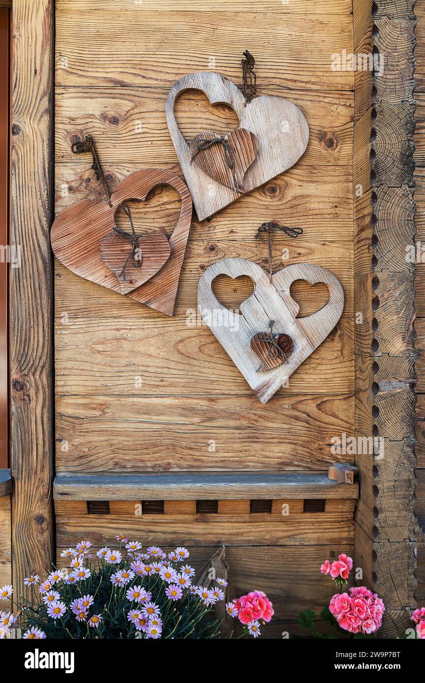 Decorazioni a forma di cuore appese a una porta rustica in legno Foto Stock