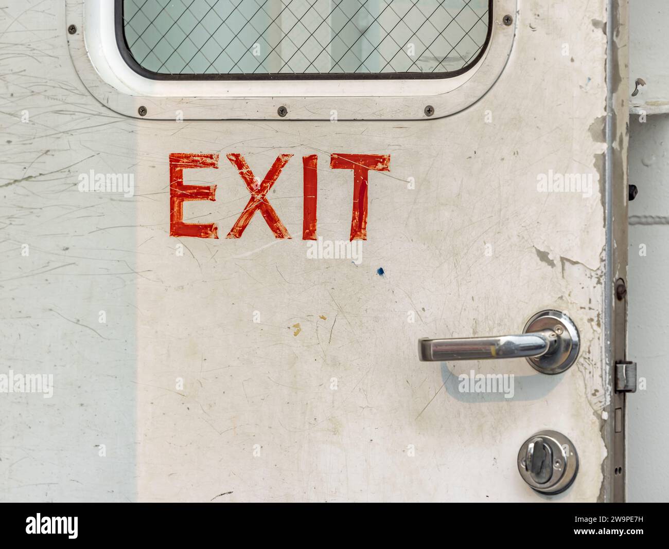 immagine dettagliata di un cartello di uscita su una vecchia porta di metallo sul traghetto dell'isola riparata Foto Stock