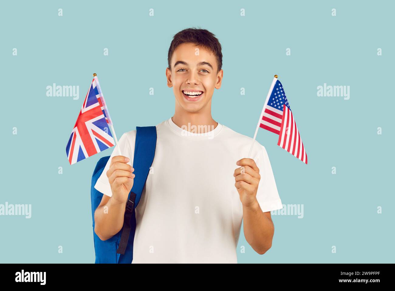 Felice e sorridente studente che impara la lingua inglese con bandiere americane e britanniche. Foto Stock