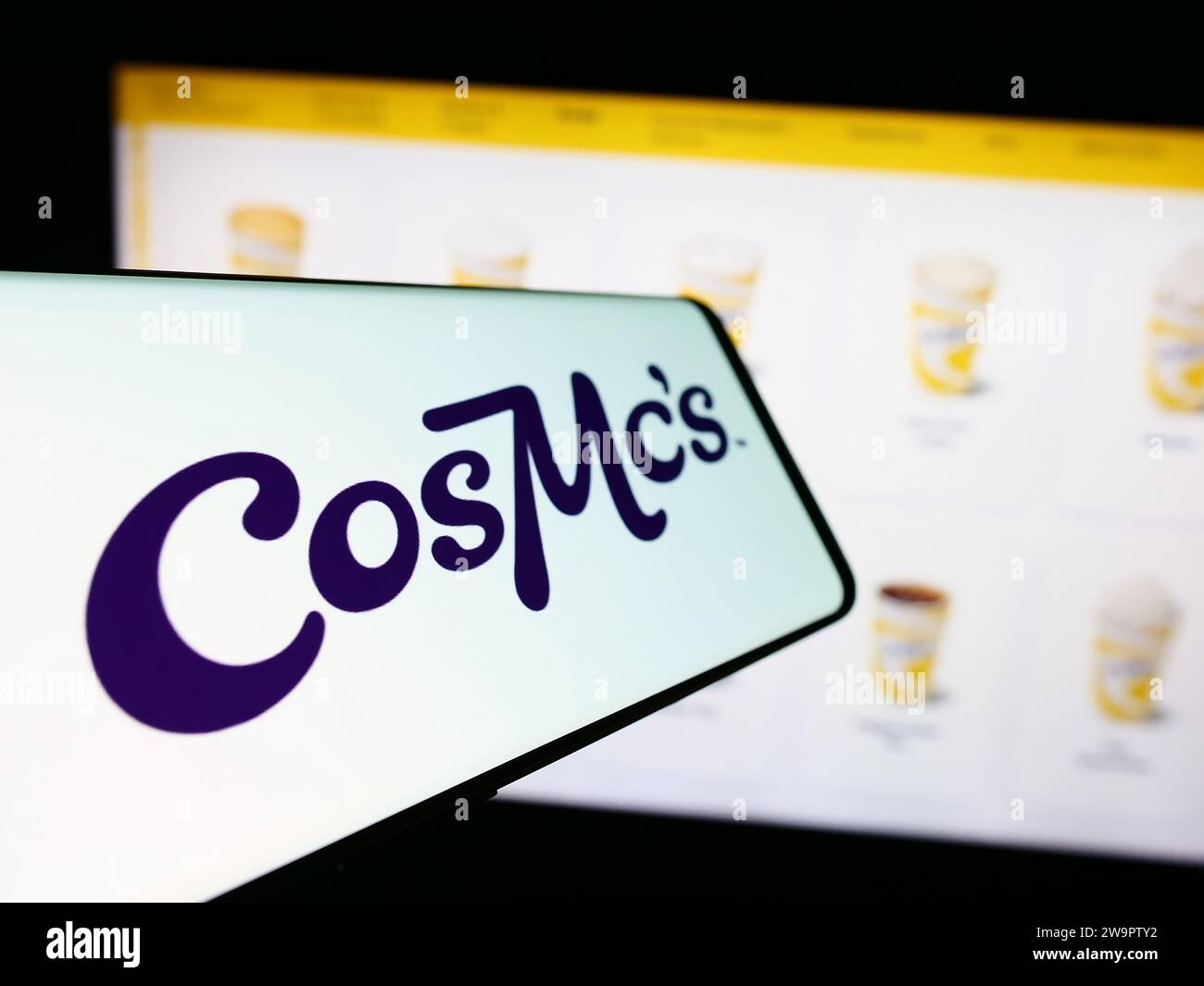 Smartphone con logo della società americana di fast food CosMc (McDonalds) davanti al sito Web aziendale. Mettere a fuoco il display centrale sinistro del telefono. Foto Stock