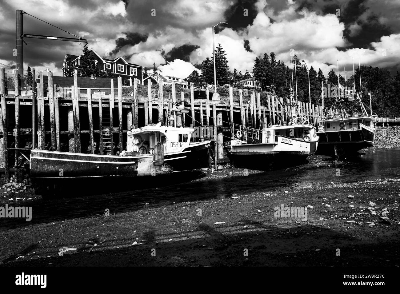 Barche da pesca con bassa marea lungo un molo a Halls Harbour, nuova Scozia, Canada. Foto Stock