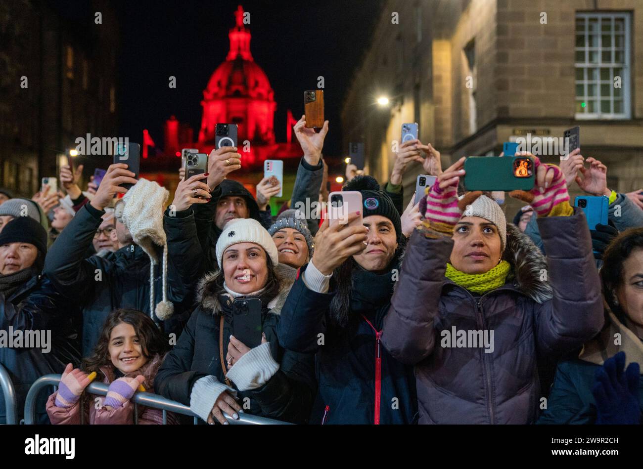 La gente guarda la processione delle fiaccole nel centro di Edimburgo, guidata dai vichinghi della Shetland South Mainland Up Helly AA Jarl Squad, come parte dell'evento di apertura per le celebrazioni di Hogmanay a Edimburgo. Data immagine: Venerdì 29 dicembre 2023. Foto Stock