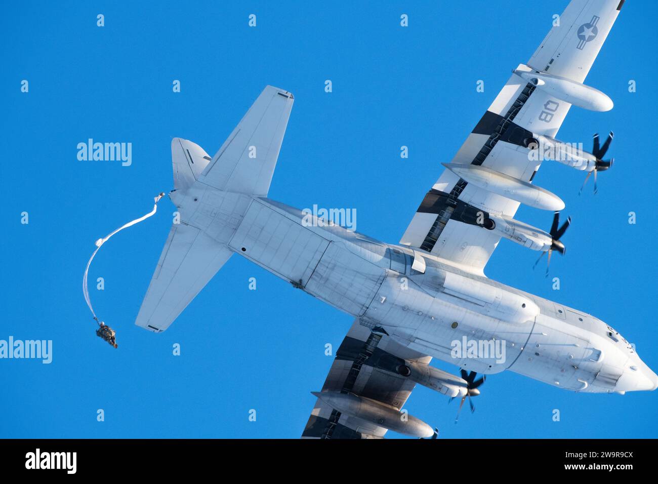 I paracadutisti dell'esercito degli Stati Uniti con il 2nd Infantry Brigade Combat Team (Airborne), 11th Airborne Division, "Arctic Angels", discendono sopra Malemute Drop zone dopo essere saltati da un corpo dei Marines degli Stati Uniti KC-130J Super Hercules durante operazioni aeree congiunte presso la base congiunta Elmendorf-Richardson, Alaska, 8 dicembre 2023. Gli aviatori del Marine Aerial Refueler Transport Squadron (VMGR) 153 della Marine Corps Air Station Kaneohe Bay, Hawaii, e i paracadutisti dell'esercito hanno condotto l'addestramento congiunto di supporto aereo per garantire la prontezza della missione in un ambiente artico. (Foto U.S. Air Force di Airman Raina Foto Stock