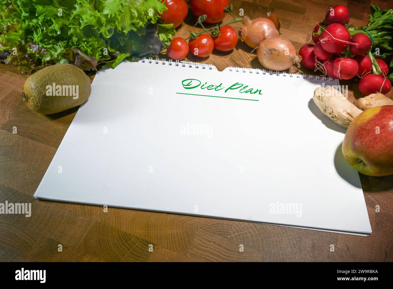 Programma di dieta, quaderno a spirale con carta bianca circondato da verdure e frutta sane a basso contenuto calorico su un tavolo rustico in legno, spazio per note o. Foto Stock