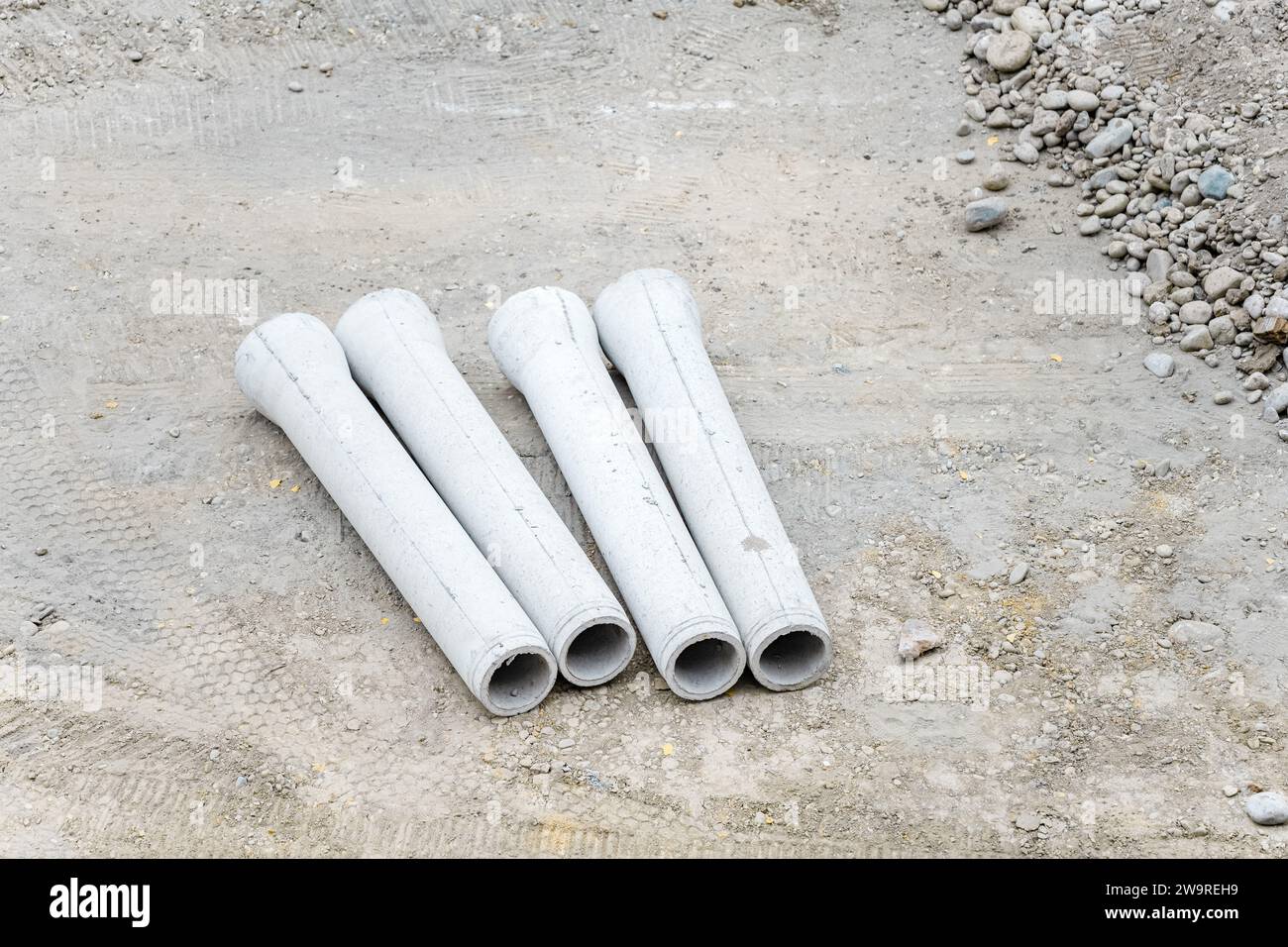 I tubi vengono innaffiati con dumper per cemento e escavatori Foto Stock
