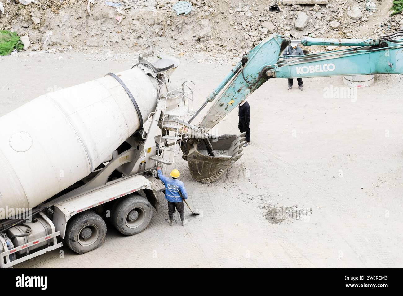 I tubi vengono innaffiati con dumper per cemento e escavatori Foto Stock