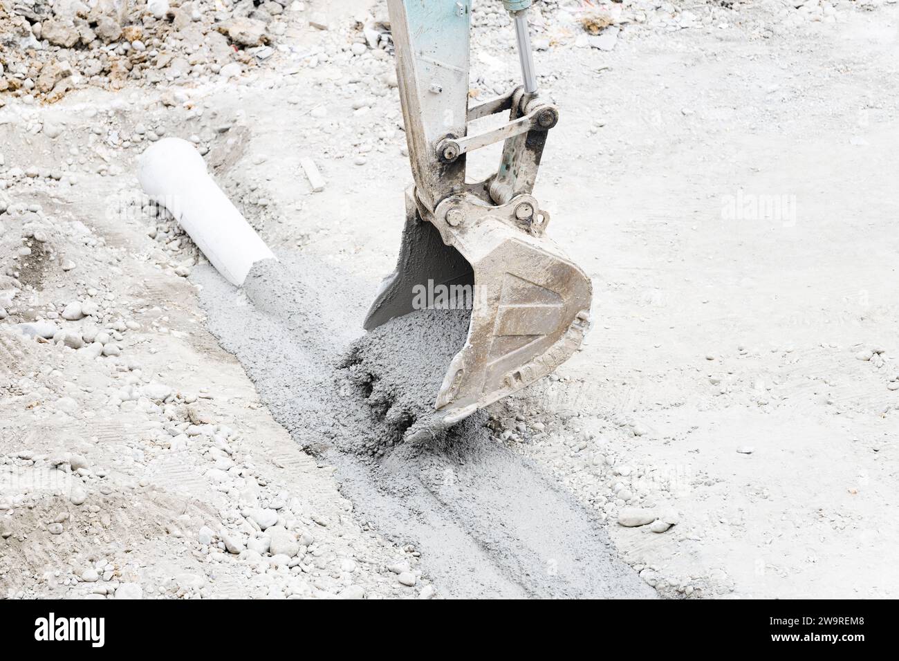 I tubi vengono innaffiati con dumper per cemento e escavatori Foto Stock