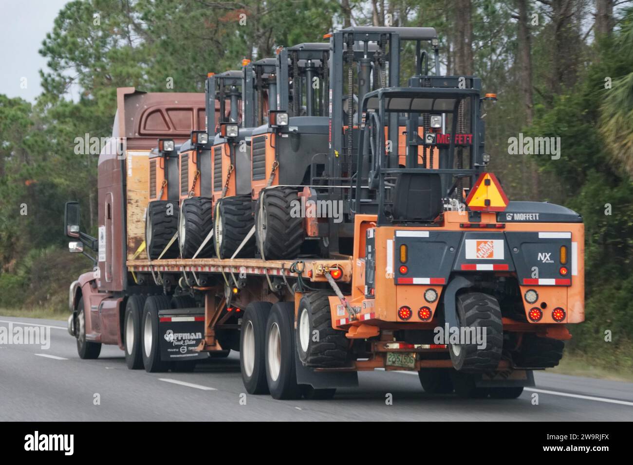 Florida, U.S.A - 14 novembre 2023 - Un camion che trasporta i carrelli elevatori Moffett in autostrada Foto Stock