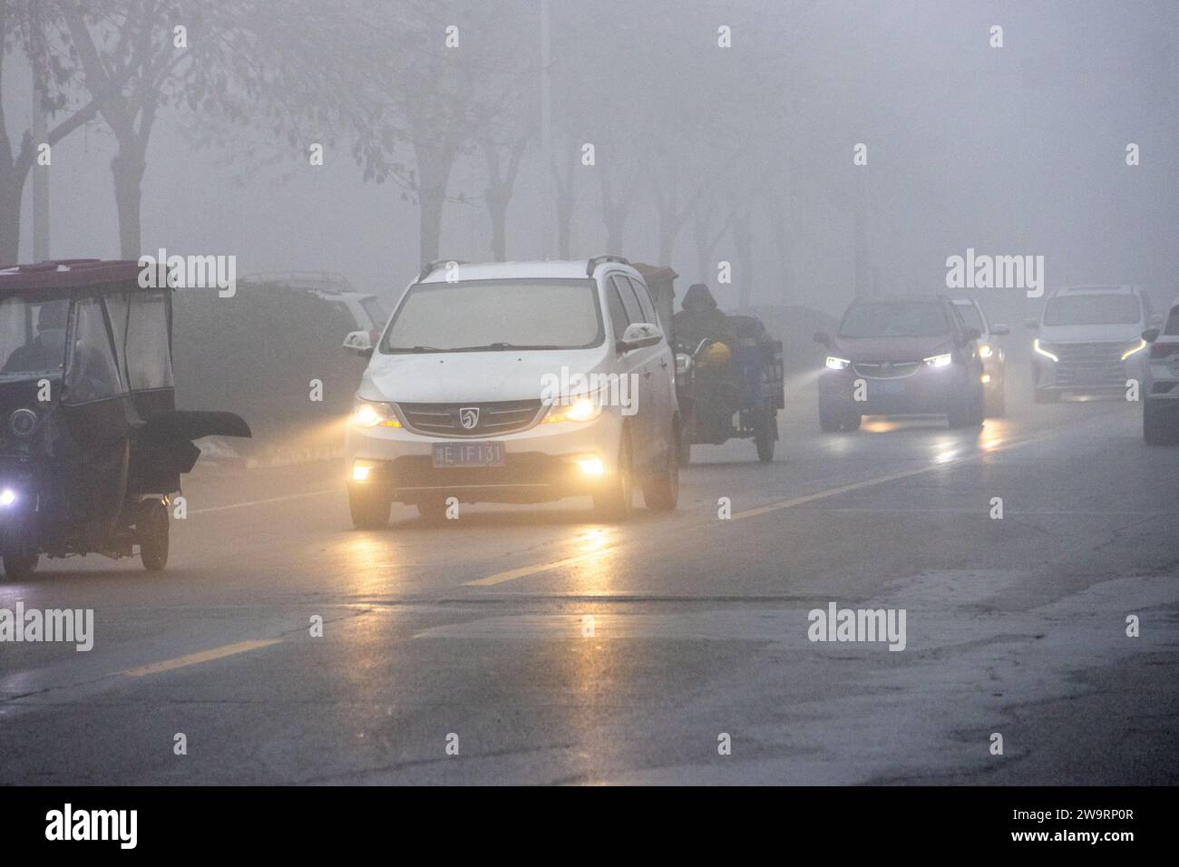 ANYANG, CINA - 30 DICEMBRE 2023 - le persone viaggiano nella nebbia pesante con visibilità inferiore a 200 metri nella contea di Hua, nella città di Anyang, provincia di Henan, chi Foto Stock