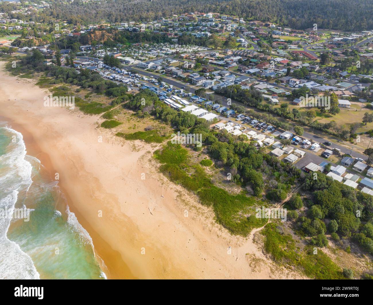 Vista aerea di un parco caravan tra una spiaggia e una cittadina costiera a Tathra, sulla costa meridionale del nuovo Galles del Sud in Australia Foto Stock