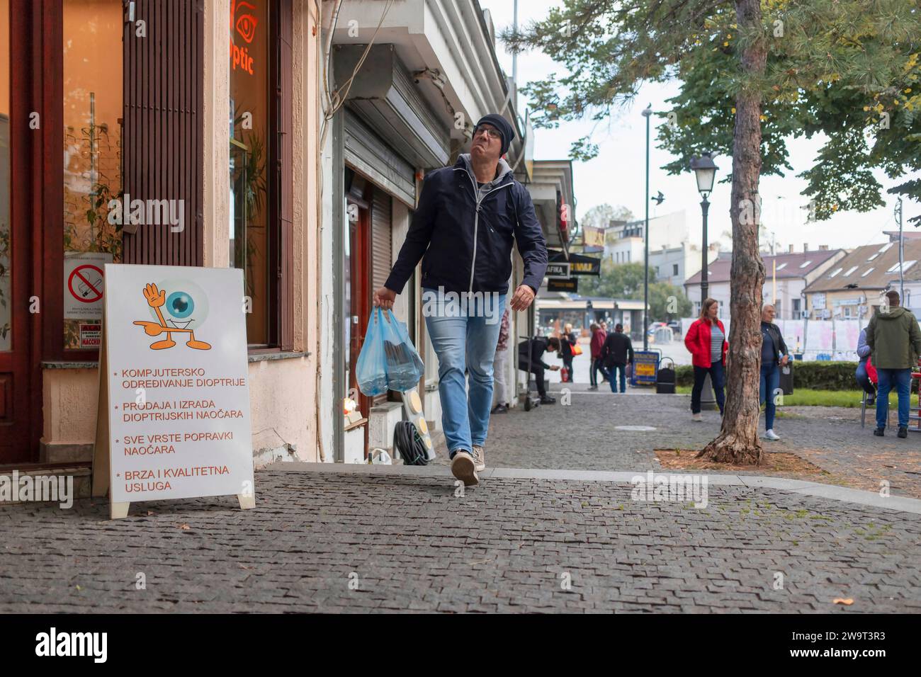Belgrado, Serbia, 7 novembre 2023: Un uomo disgustoso che porta sacchetti di fast food lascia il mercato di Zemun Foto Stock