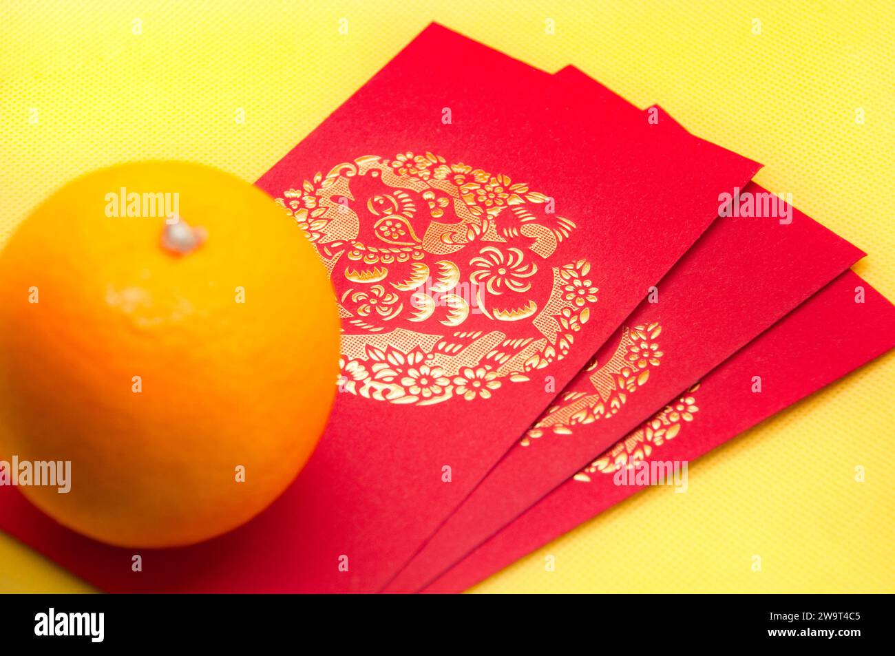 Confezioni rosse di Capodanno cinese e arancioni su sfondo giallo della copertina. Concetto cinese di stagione festiva. Foto Stock