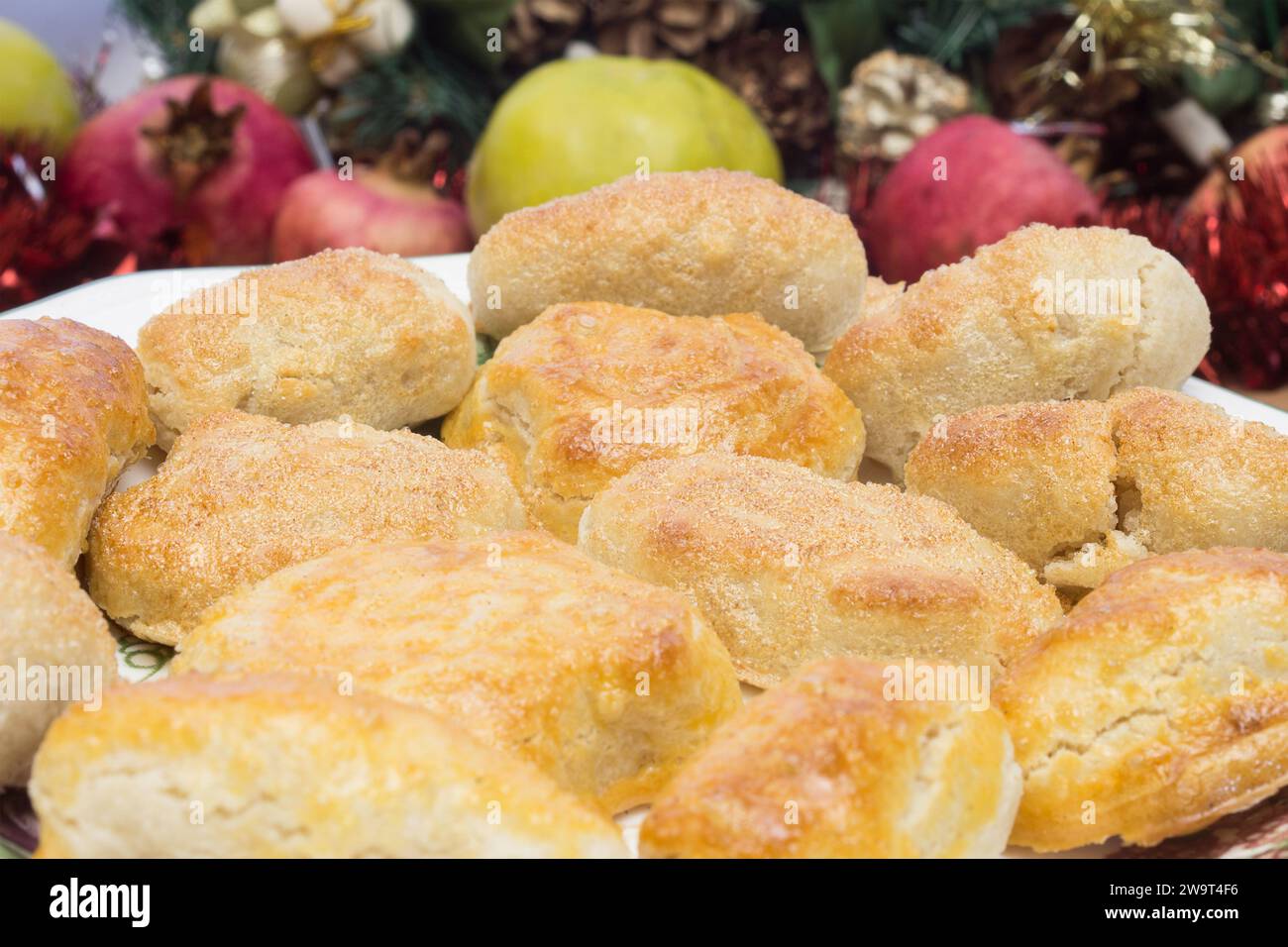 Marziane di mandorle fatte in casa festose e appetitose su un piatto di porcellana circondato da decorazioni natalizie, che donano un tocco di dolcezza e allegria. Foto Stock