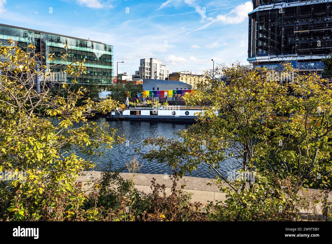 Barca ormeggiata nel Regent's Canal lungo il Regent's Canal Towpath vicino ai Wharf Road Gardens, con Battlebridge Basin sullo sfondo, Londra, Regno Unito Foto Stock