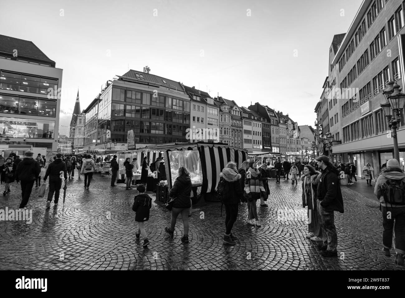 Bonn, Germania - 23 dicembre 2023: Veduta di un mercato all'aperto che vende frutta e verdura fresca nella piazza del mercato di Bonn Germania al tramonto Foto Stock