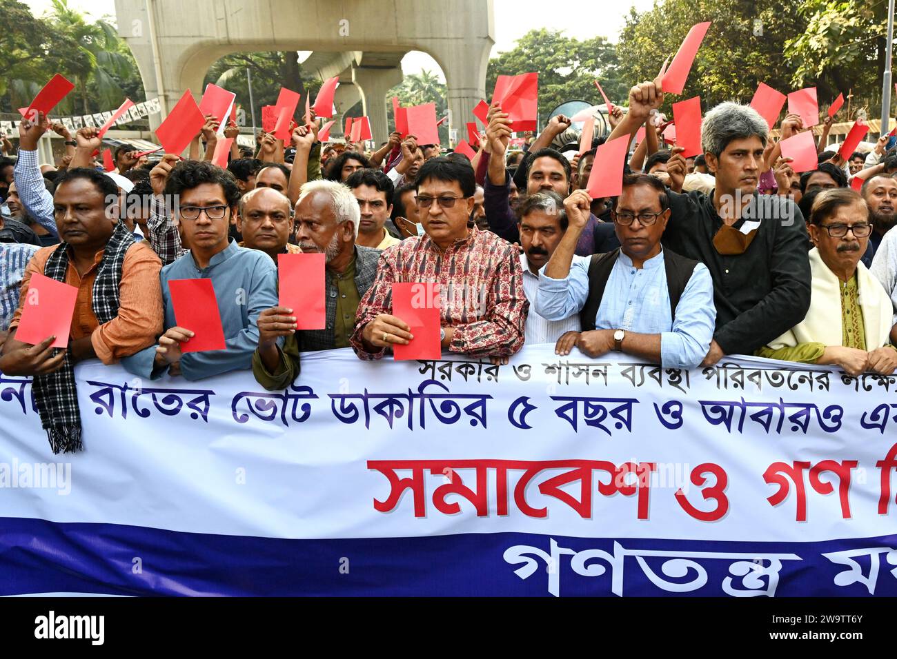 Gli attivisti dell'Alleanza del Partito di sinistra 'Ganatantra Mancha' hanno il cartellino rosso mentre prendono parte a una manifestazione per protestare contro le imminenti elezioni generali del 2024 a Dacca, Bangladesh, il 30 dicembre 2023. Credito: Mamunur Rashid/Alamy Live News Foto Stock