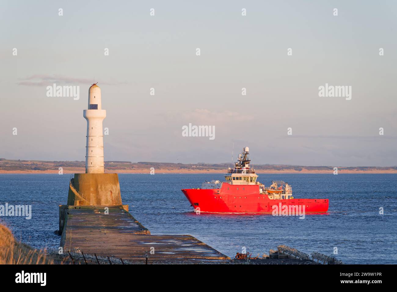 Nave che arriva al porto di Aberdeen dopo aver superato il faro di Girdle Ness Foto Stock