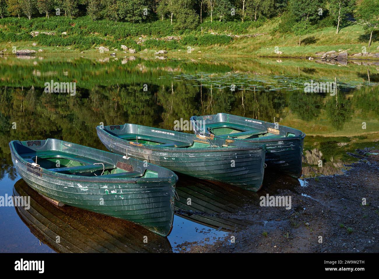 Barche a remi ormeggiate a Watendlath Tarn nel Lake District Cumbria Foto Stock