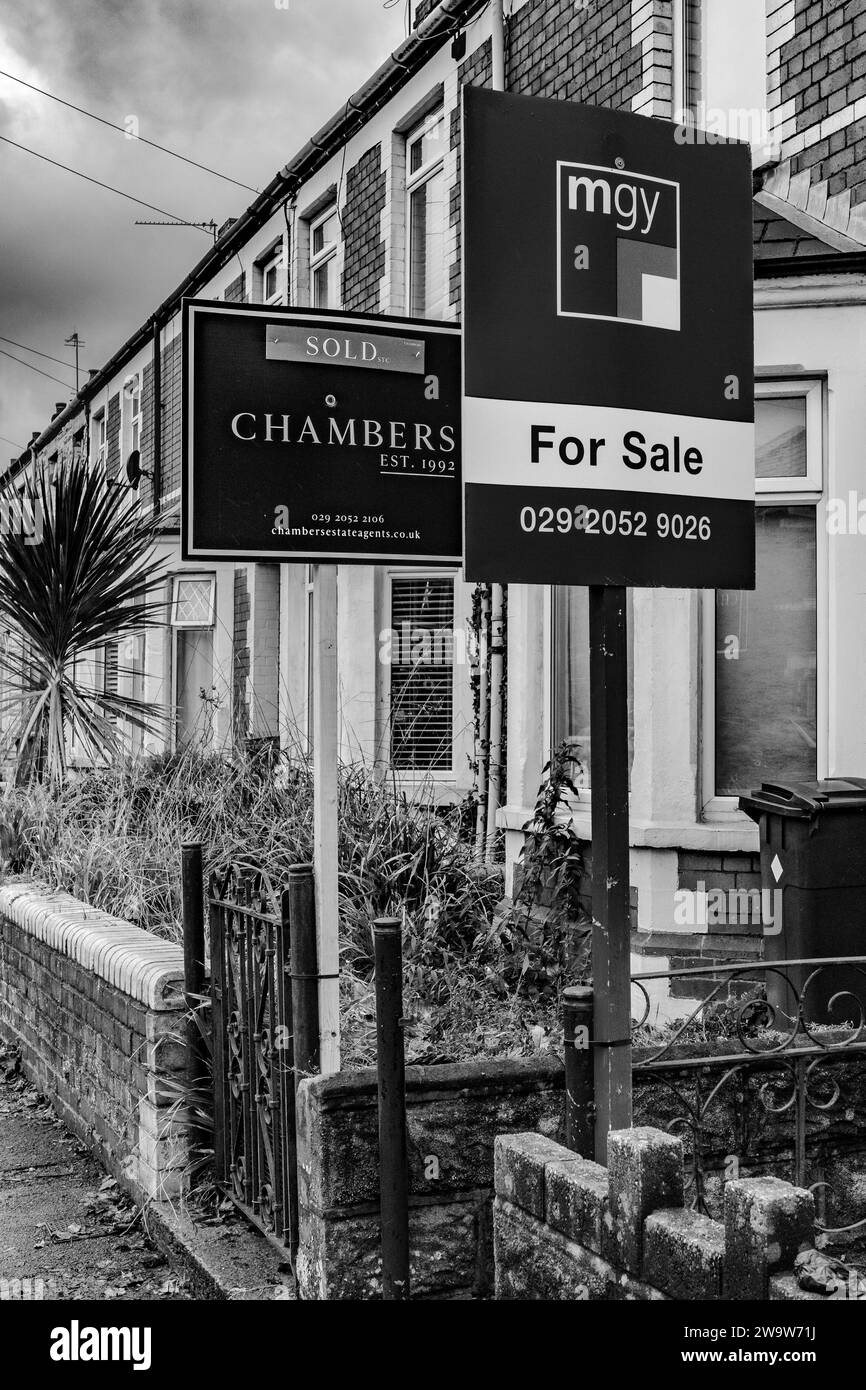 Gli agenti immobiliari per la vendita firmano e vendono cartelli su una fila di case del Regno Unito. Mercato immobiliare, mercato immobiliare, economia. Mutui. Finanza. Foto Stock