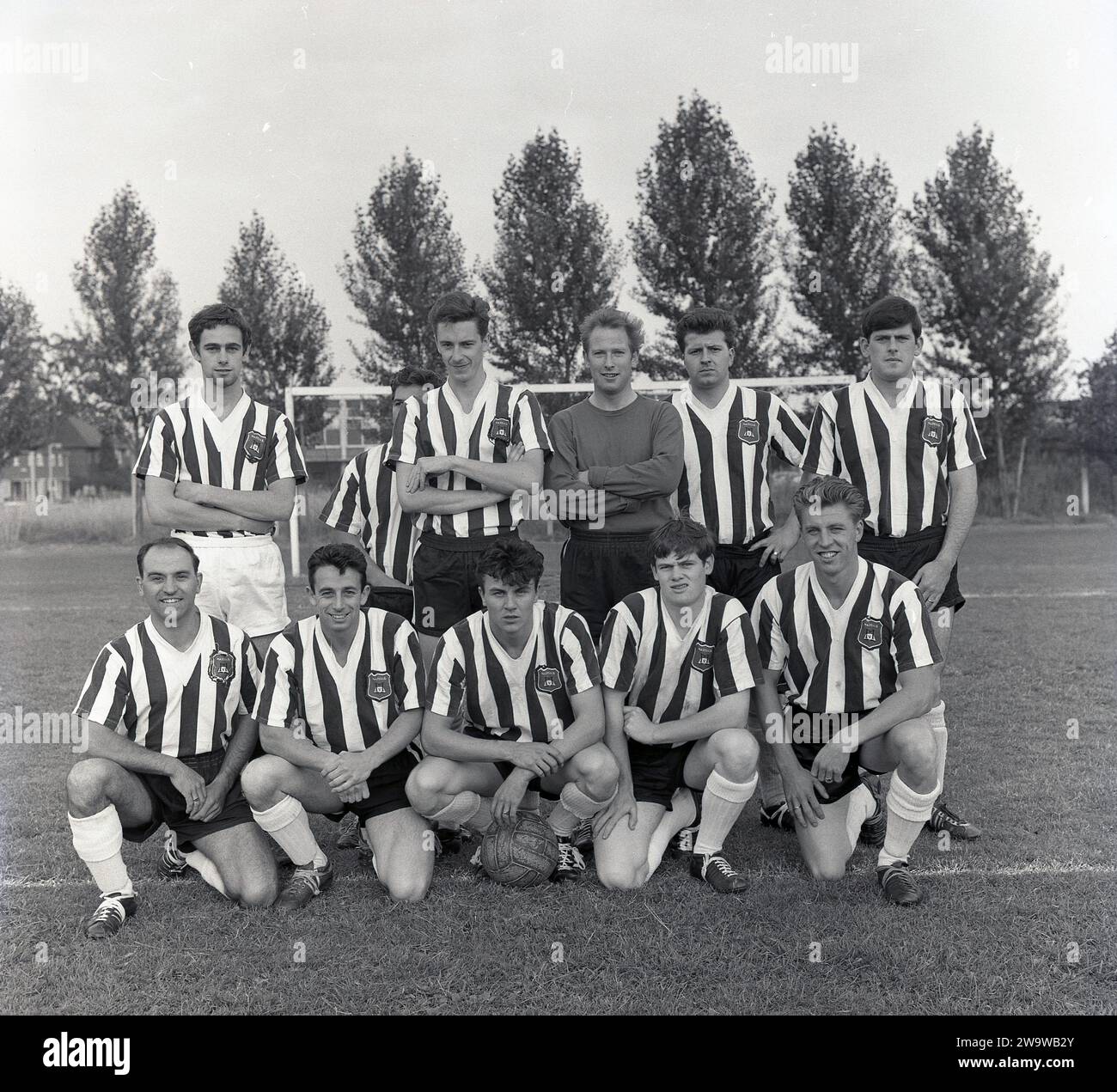 1964 agosto, Hazells (Aylesbury) FC foto squadra. Giocatori con maglie con scollo a V, logo del club, ma nessuna pubblicità commerciale o marchio sulla loro maglia. In quest'epoca, l'Hazells (Aylesbury) FC giocò nella Hellenic (Premier) League. Foto Stock