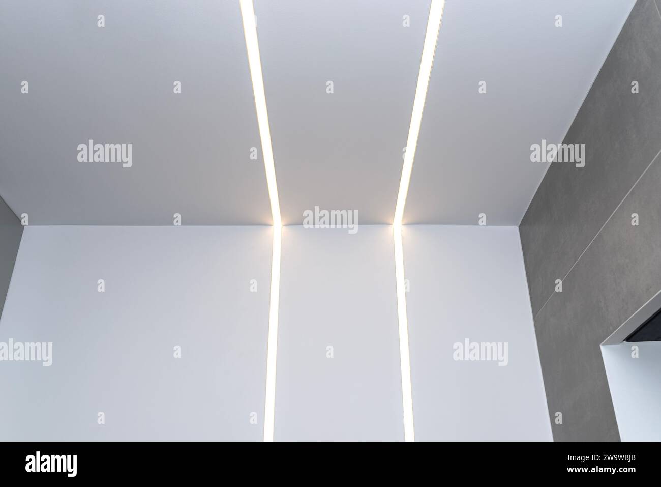 Strisce luminose a LED montate a parete e a soffitto in un bagno moderno. Foto Stock