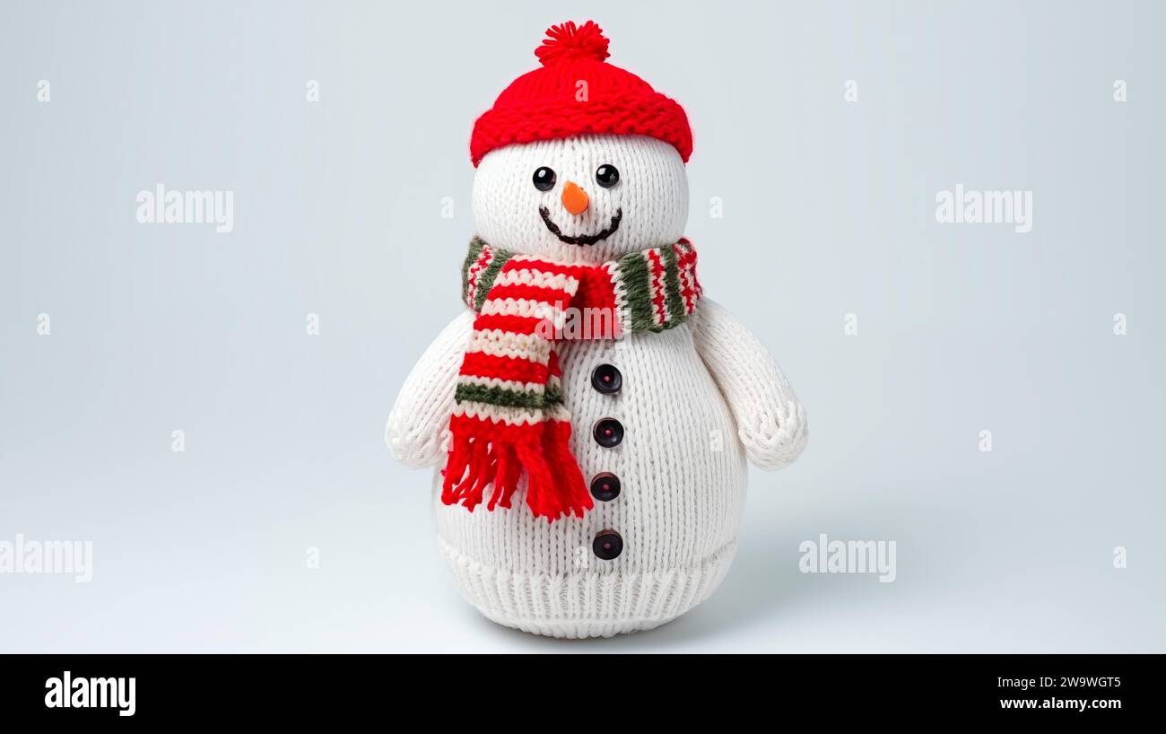 Un pupazzo di neve con cappello e sciarpa a maglia rossa su sfondo bianco. Foto Stock