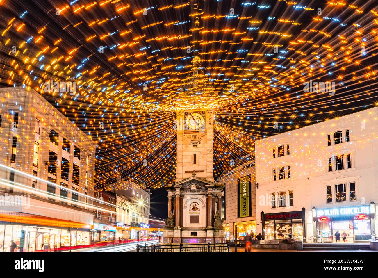 Brighton, East Sussex, Regno Unito, 30 dicembre 2023. La torre dell'orologio del Giubileo è incastonata dalle luci natalizie che sbiadono e soffiano in giro con il tempo tempestoso mentre il traffico circonda la zona e gli acquirenti sono alla ricerca di occasioni in questa trafficata città sulla costa sud.©Sarah Mott / Alamy Live News. Foto Stock