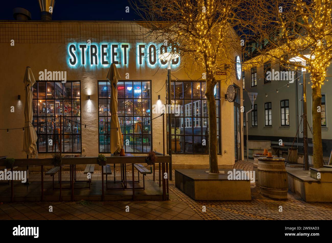 Vista notturna HDR di un ristorante di Street food dai colori vivaci e un cartello blu a Fredericia, Danimarca, 27 dicembre 2023 Foto Stock
